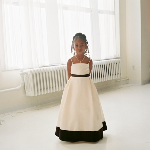 photo by New York City based wedding photographer Karen Hill - adorable flower girl in ivory dress with black trim 